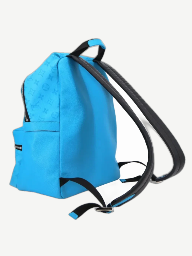 Side profile of Louis Vuitton blue Taigarama Discovery backpack showing monogram embossing and black leather straps