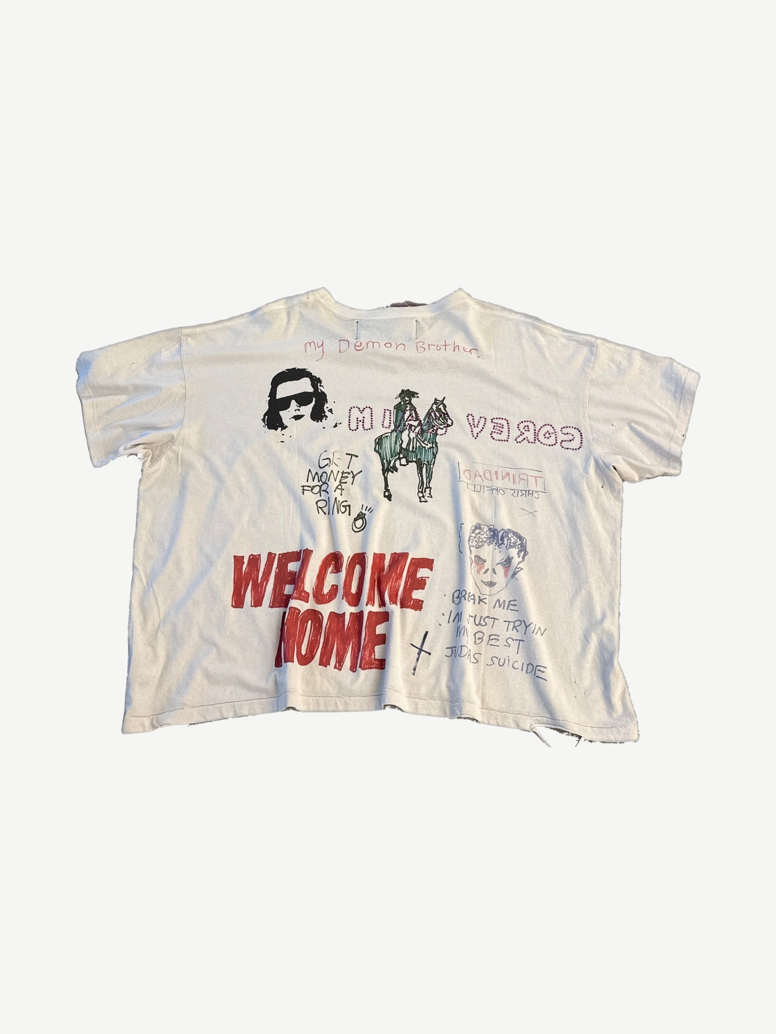 Paly Hollywood off-white tee back with red Welcome Home text, cowboy on horse, Trinidad and Judas Suicide scrawls.