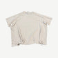 Paly Hollywood cream cropped tee back view showing heavy distressing, holes and raw torn hemline