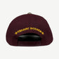 Chrome Hearts burgundy cap back with yellow Chrome Hearts script and cross flowers, snapback closure.
