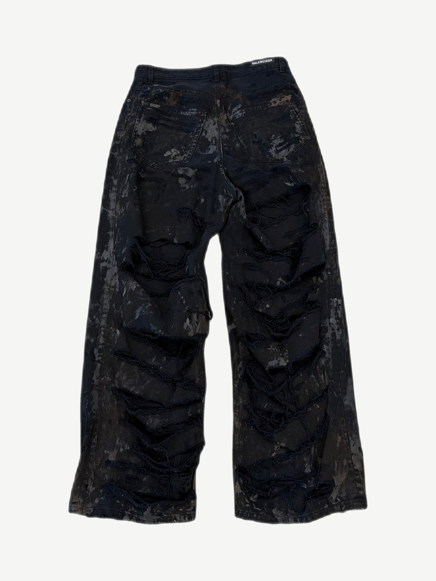Back of Balenciaga mud wash destroyed jeans showing ripped pocket detailing and oversized straight leg silhouette.
