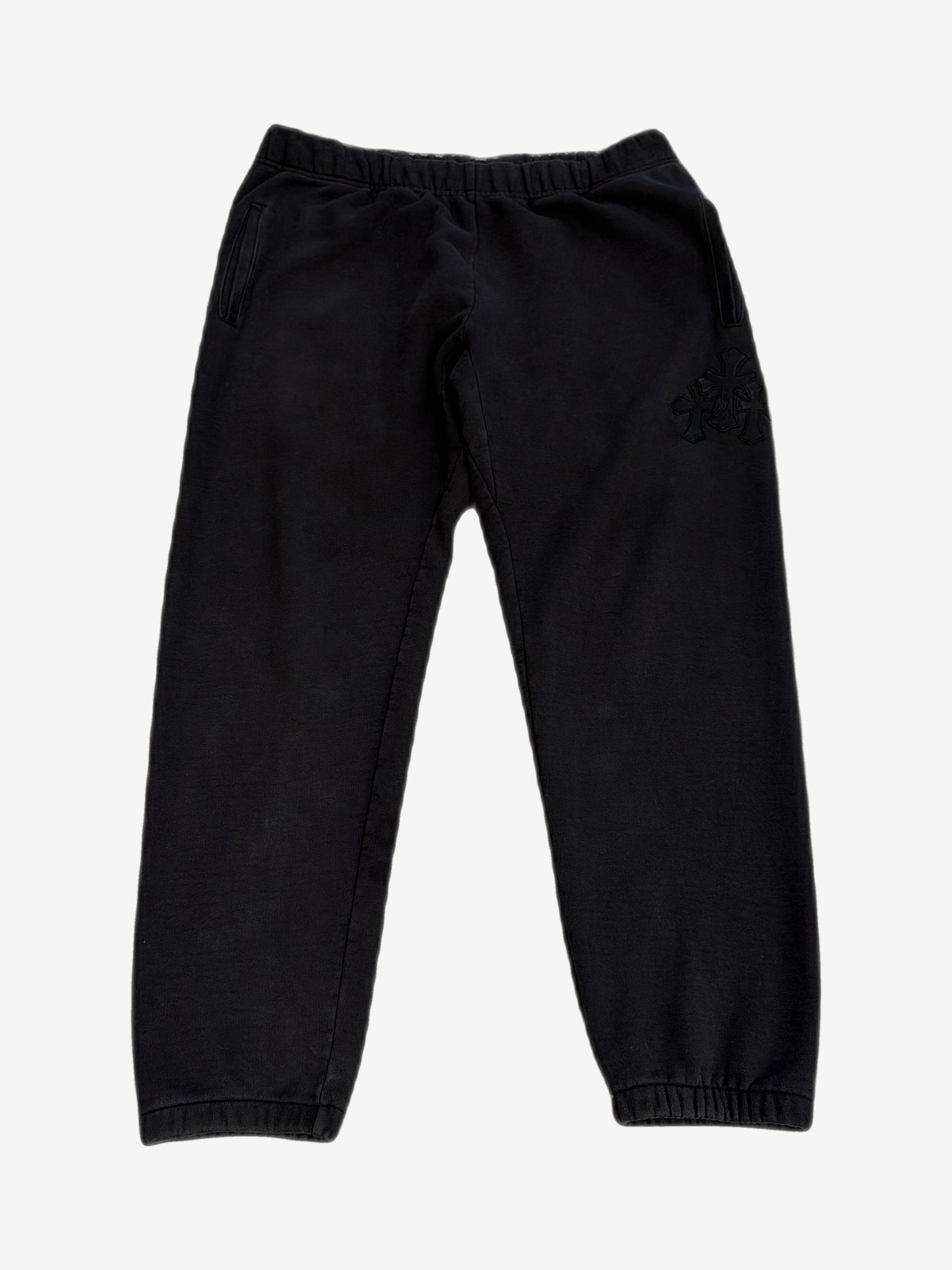 Chrome Hearts black Paper Jam sweatpants with cluster of black leather cross patches on right thigh