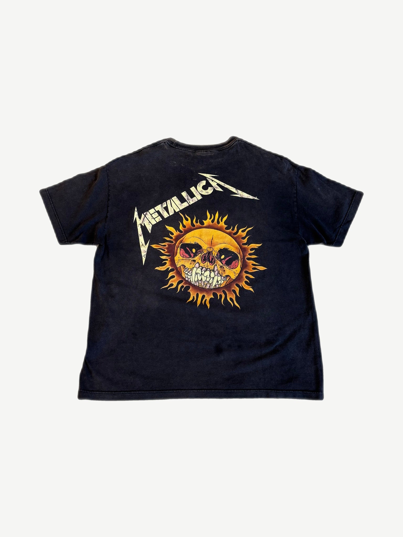 Vintage Metallica Pushead flaming skull tee back view with sun faded black cotton and ringer collar