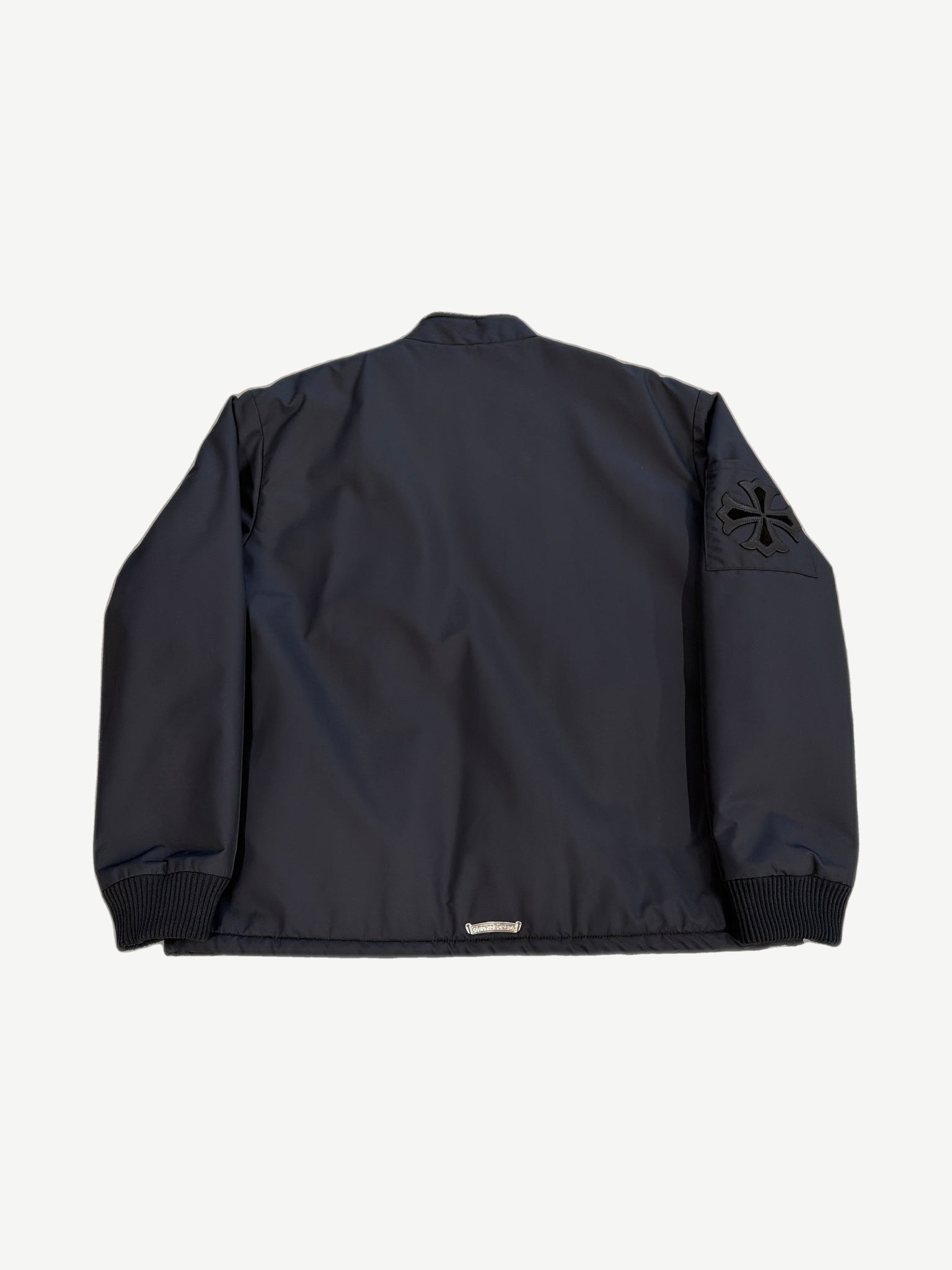Chrome Hearts black Cobra racing jacket back view with black leather cross patch on right sleeve
