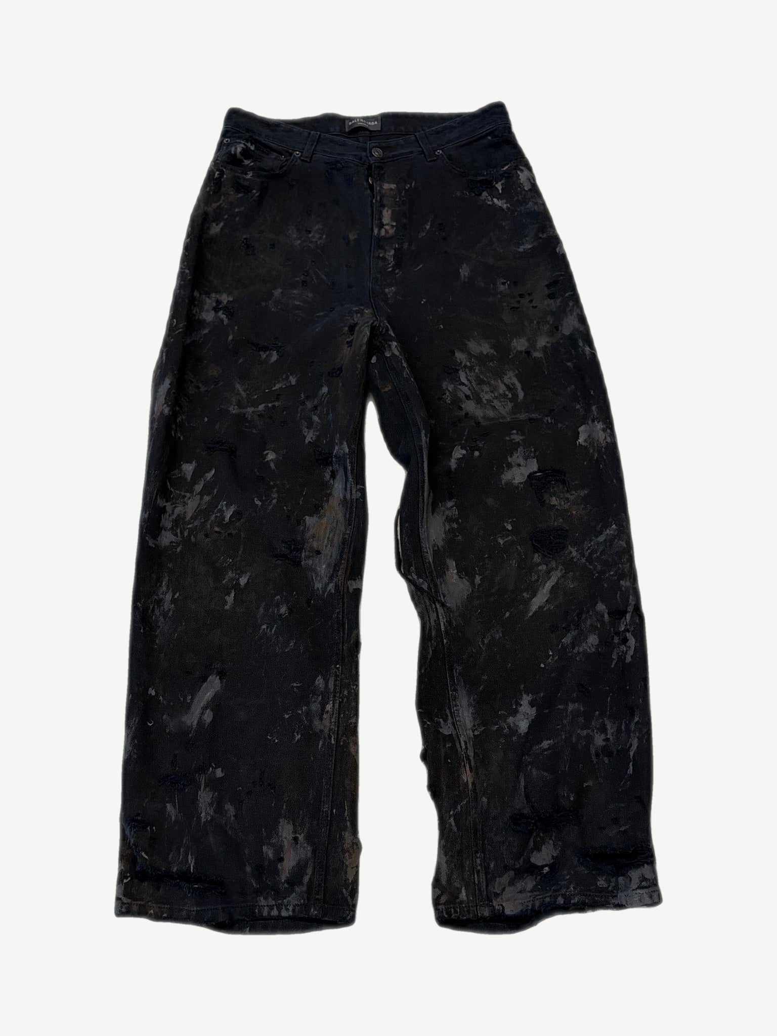 Balenciaga mud wash destroyed denim jeans with heavy distressing, shredded knees and faded brown earth tones.
