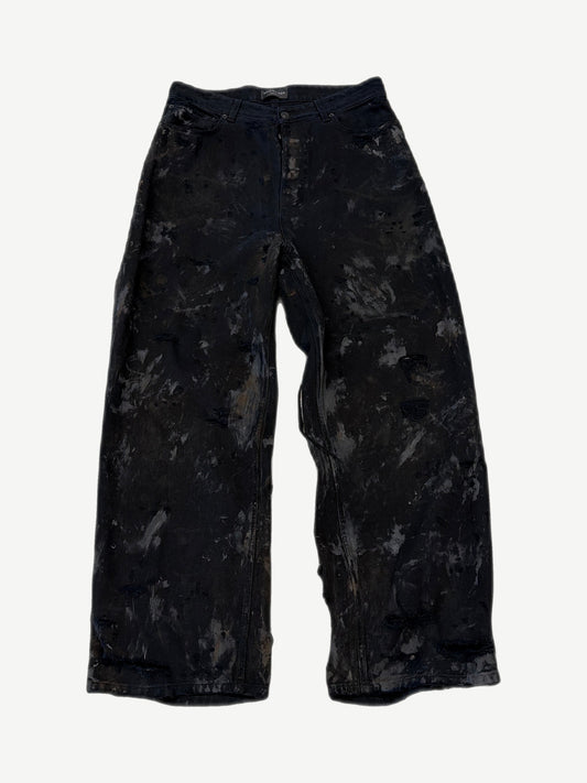 Balenciaga mud wash destroyed denim jeans with heavy distressing, shredded knees and faded brown earth tones.