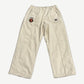 Supreme x Umbro stone cotton ripstop track pant front, wide leg with Supreme World Famous crest patch on thigh.