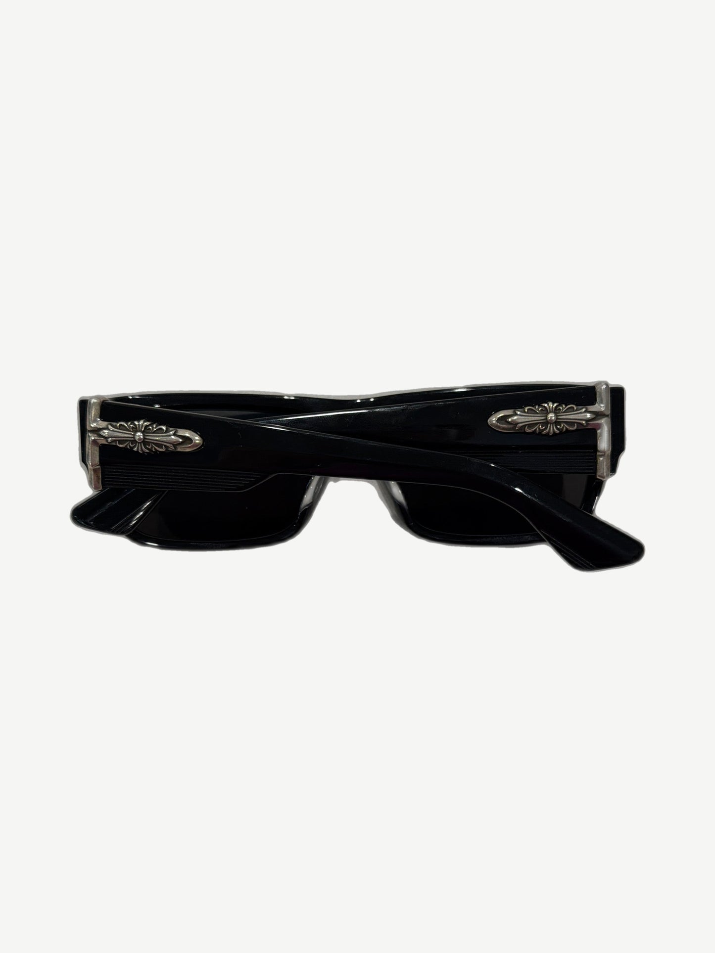 Chrome Hearts Yer Born Again sunglasses side angle showing silver cross dagger hinge hardware on black temple.