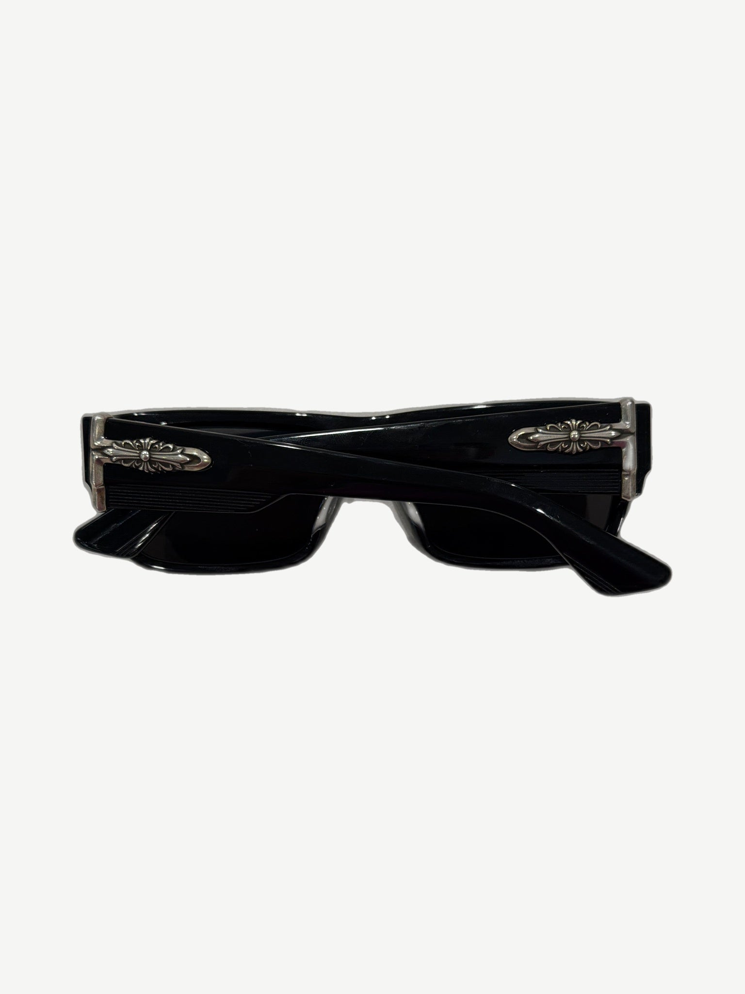 Chrome Hearts Yer Born Again sunglasses side angle showing silver cross dagger hinge hardware on black temple.