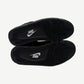 Outsole view of Air Jordan 4 Black Cat 2025 with black rubber tread and white Nike branding on midfoot pivot