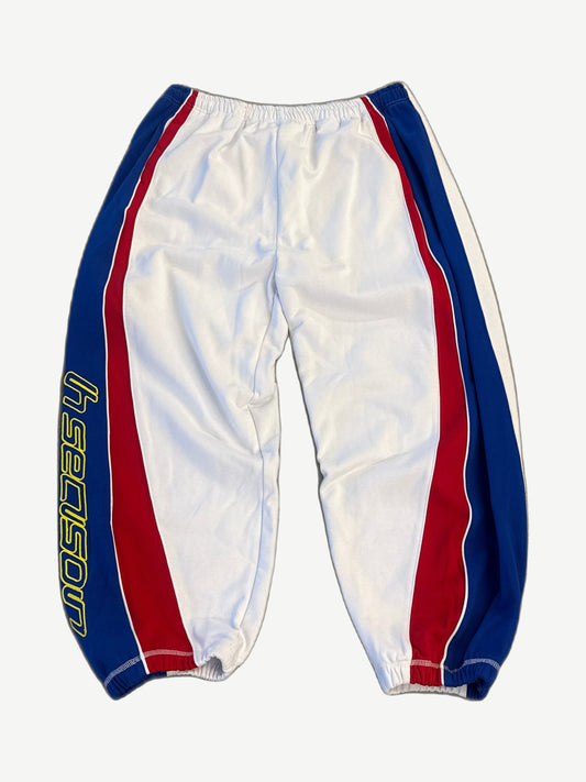 Hidden Season white athletic sweatpants with blue and red racing stripe side panels and yellow brand logo