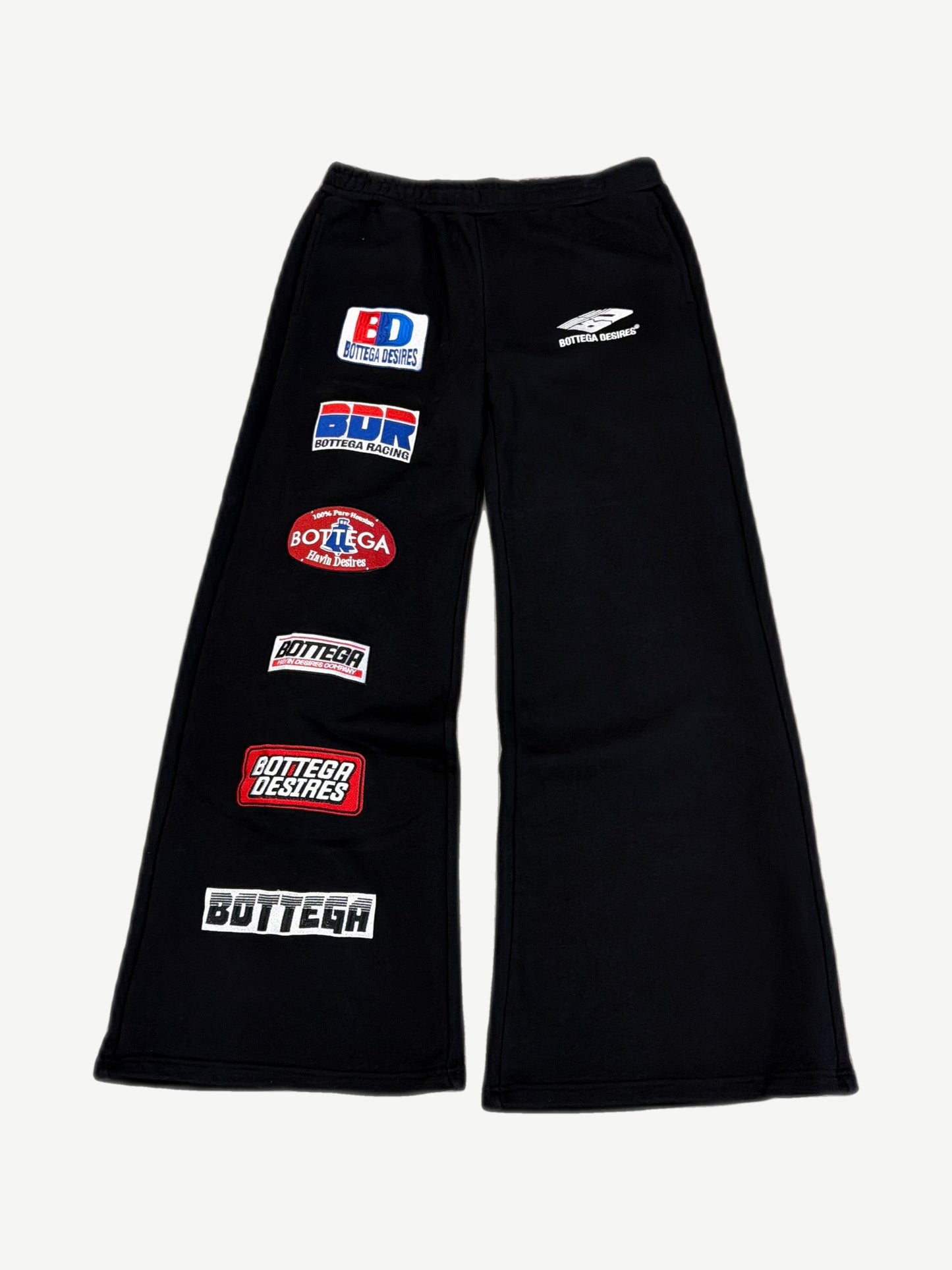 Bottega Desires black flared sweatpants with multiple racing-style brand patches down the left leg