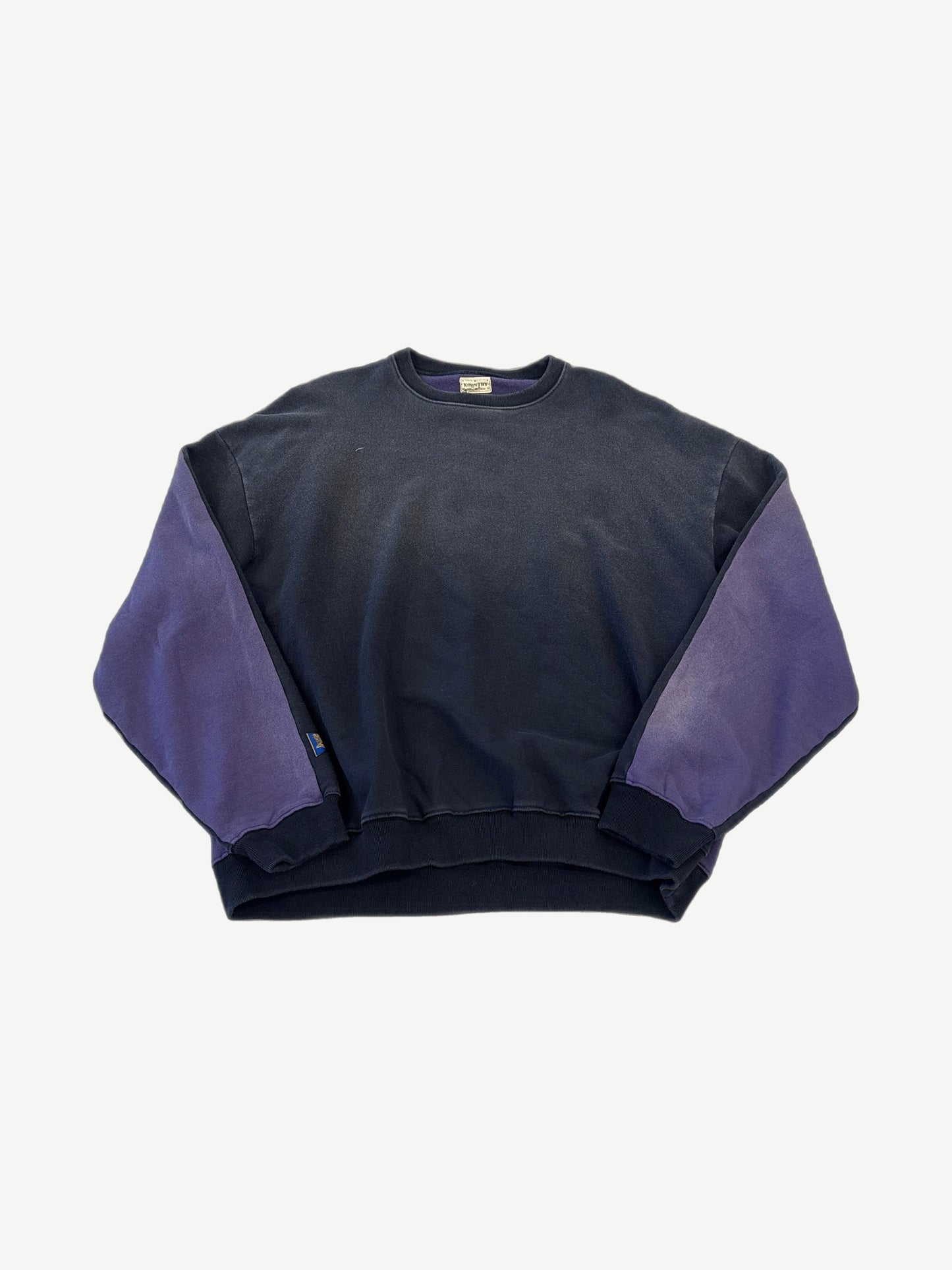 Kapital two-tone crewneck sweatshirt front in faded black body with contrasting purple sleeves and ribbed hem