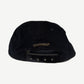 Chrome Hearts black corduroy cap angled view showing blue dagger crest and curved bill silhouette.