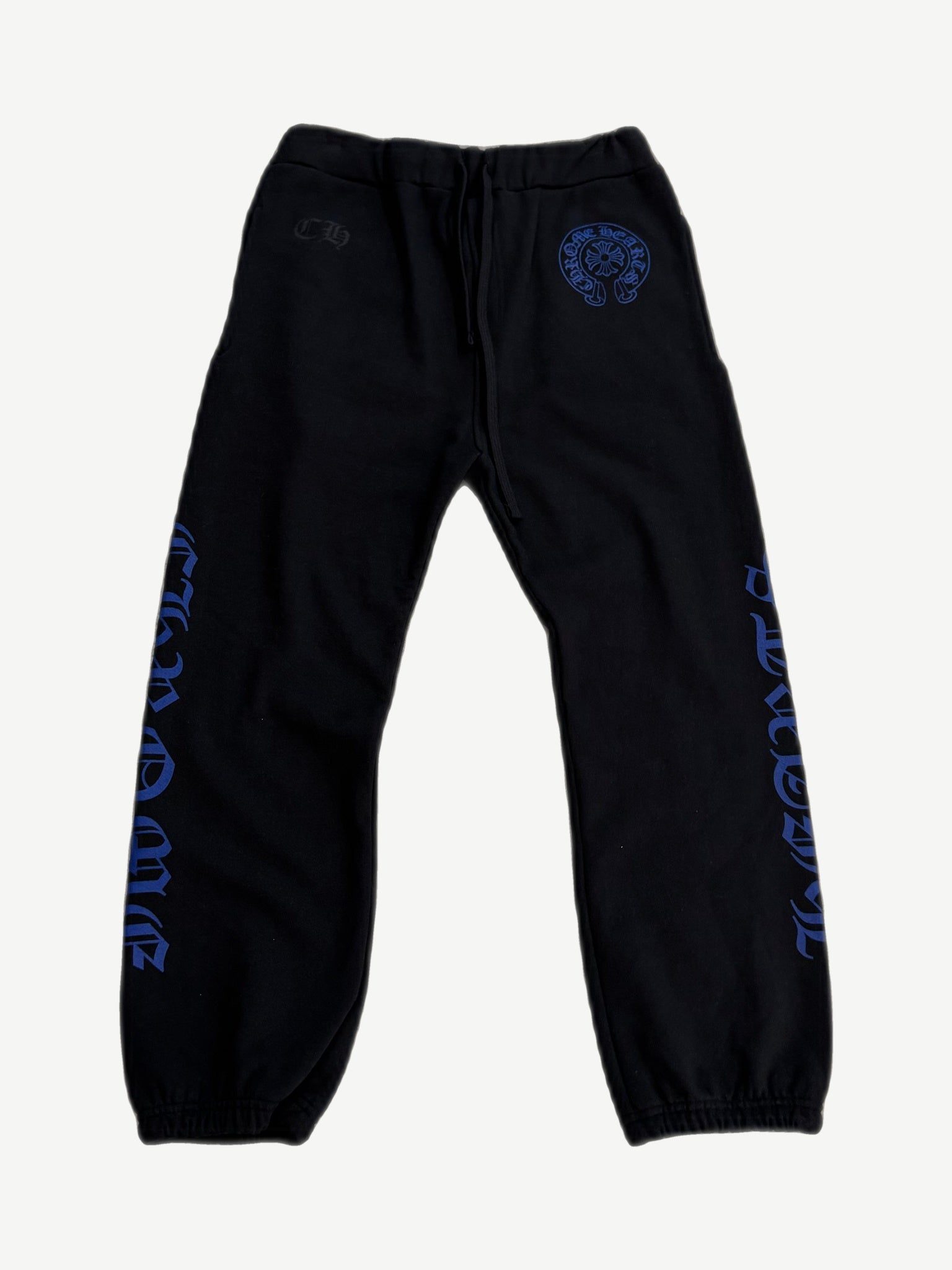Chrome Hearts black sweatpants front view with blue horseshoe logo at waist and gothic text down both legs