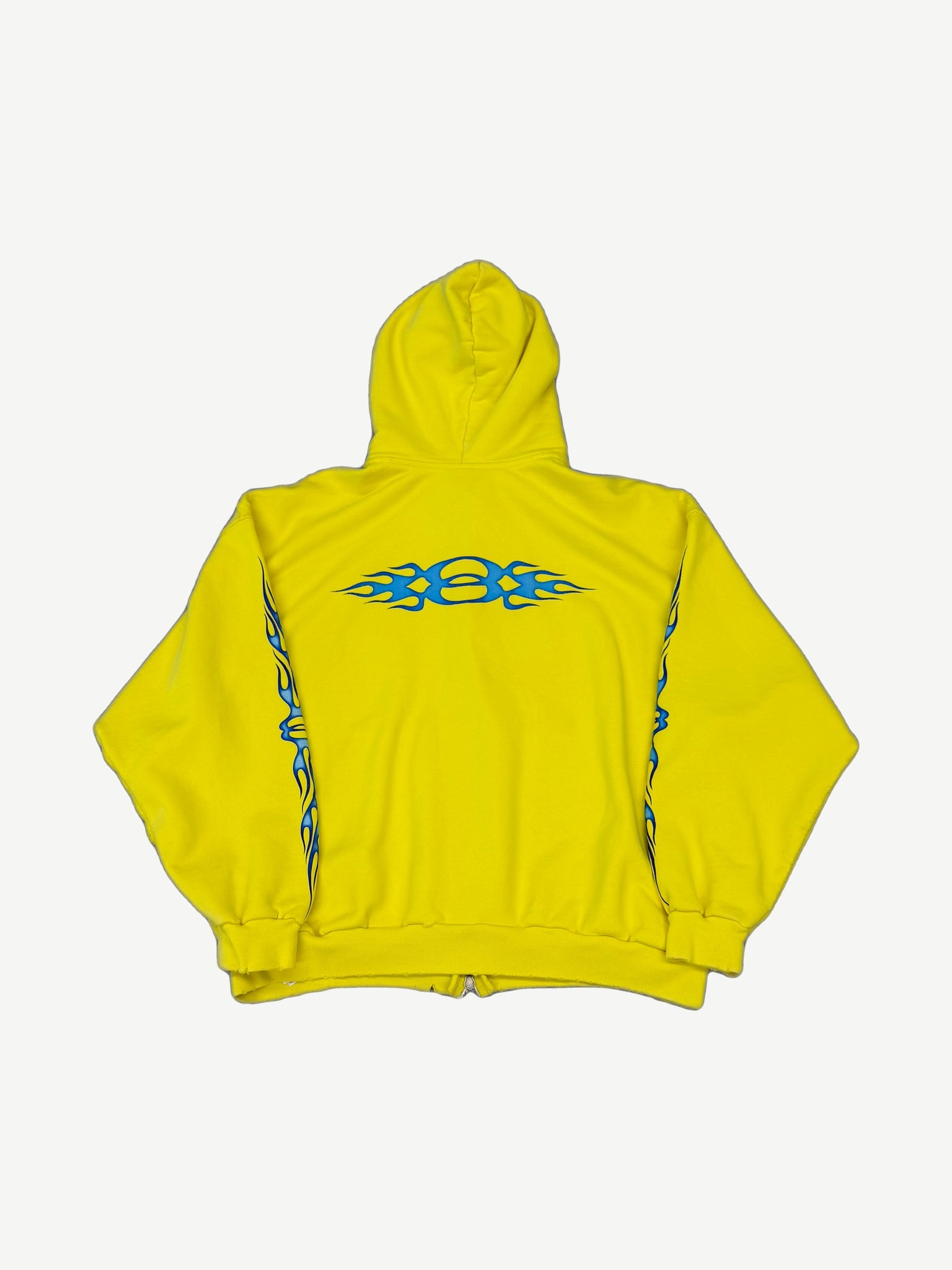 Balenciaga yellow Unity flame zip hoodie back, large blue tribal flame graphic across shoulders and sleeves.