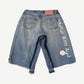 Better With Age pin jean shorts angled view, washed blue denim adorned with custom pin clusters