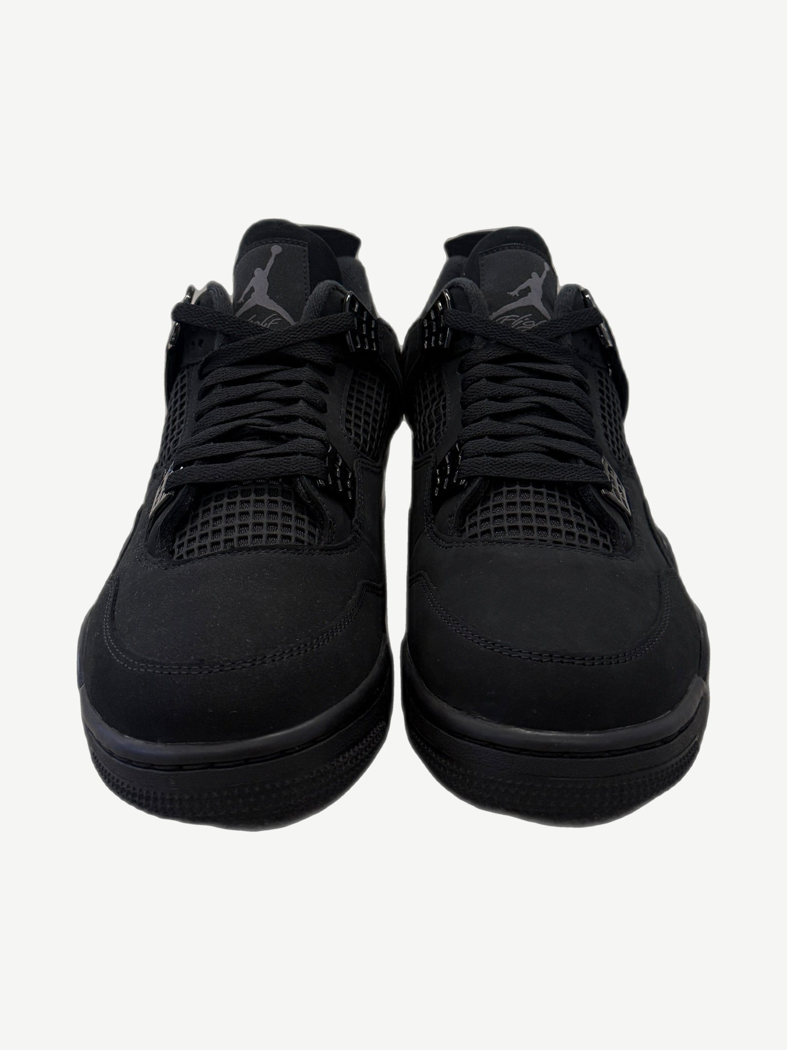 Front view of Air Jordan 4 Black Cat 2025 with reflective Jumpman tongue tag and triple-black nubuck upper