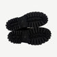 Balenciaga Combat Strike boot sole detail showing aggressive deep lug tread with debossed BALENCIAGA branding.