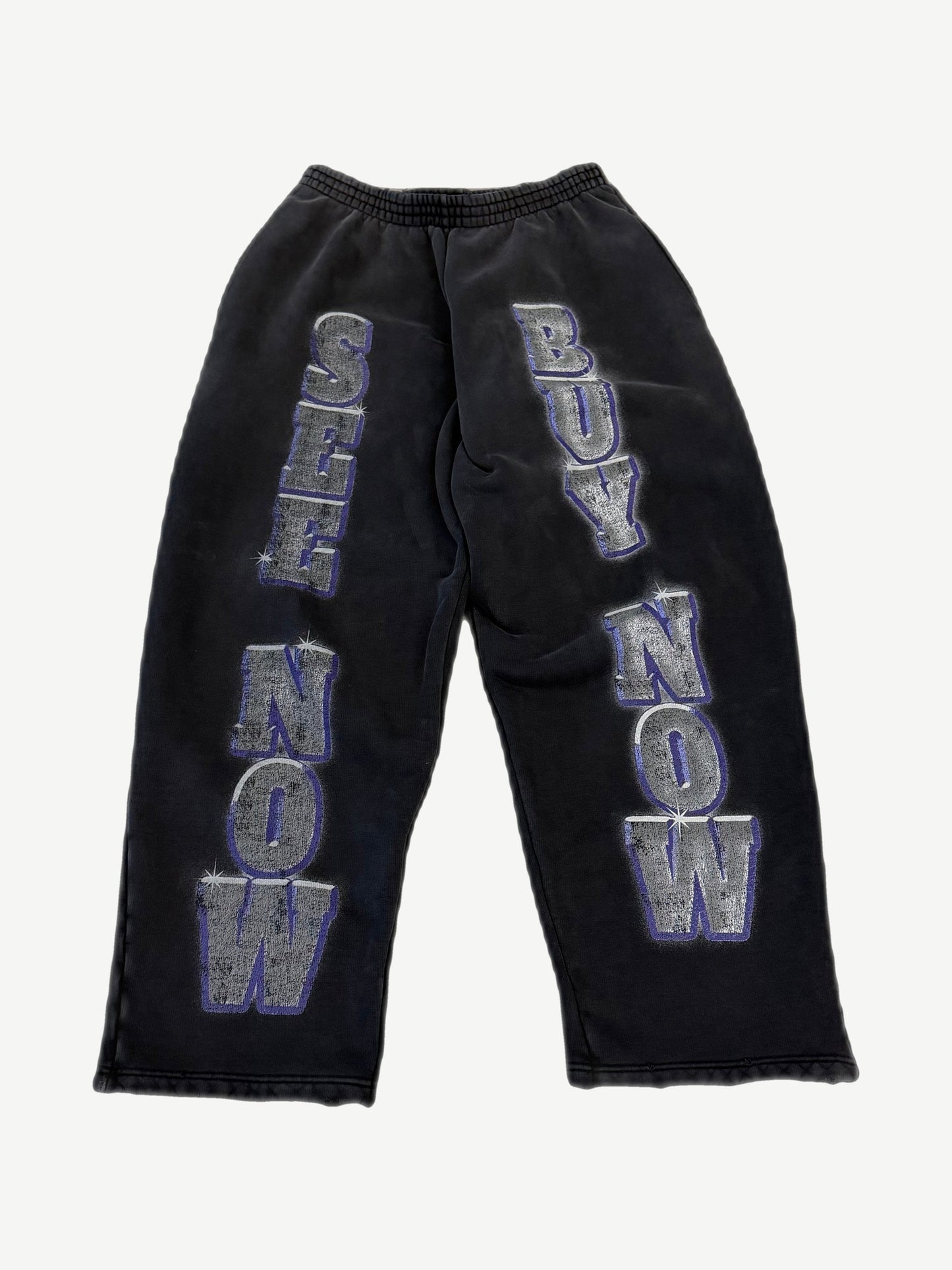 Balenciaga washed black sweatpants with large See Now Buy Now silver and purple block letter print on legs