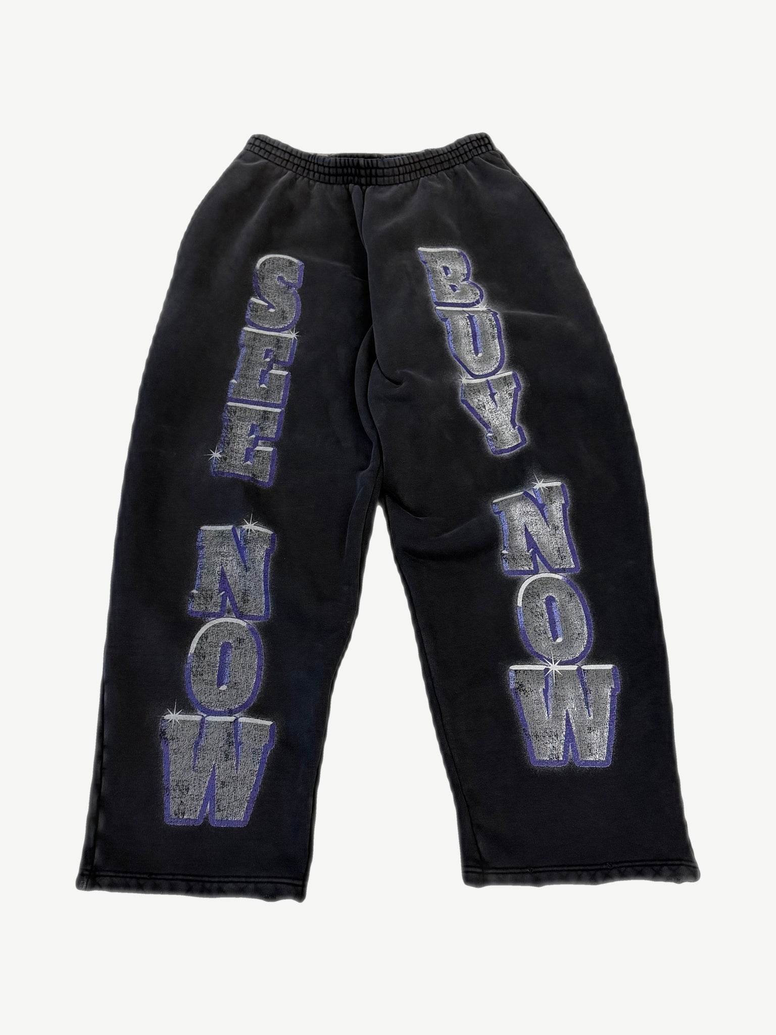 Balenciaga washed black sweatpants with large See Now Buy Now silver and purple block letter print on legs