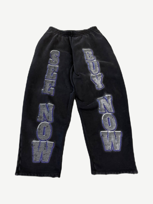 Balenciaga washed black sweatpants with large See Now Buy Now silver and purple block letter print on legs