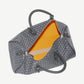Interior view of Goyard Boston 50 duffle showing bright yellow lining and gray chevron canvas exterior