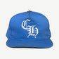 Chrome Hearts light blue baseball cap front with white Old English CH embroidery and silver cross stud.
