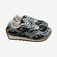 Bottega Veneta dark green Orbit sneaker side profile with chunky white sole and woven leather.