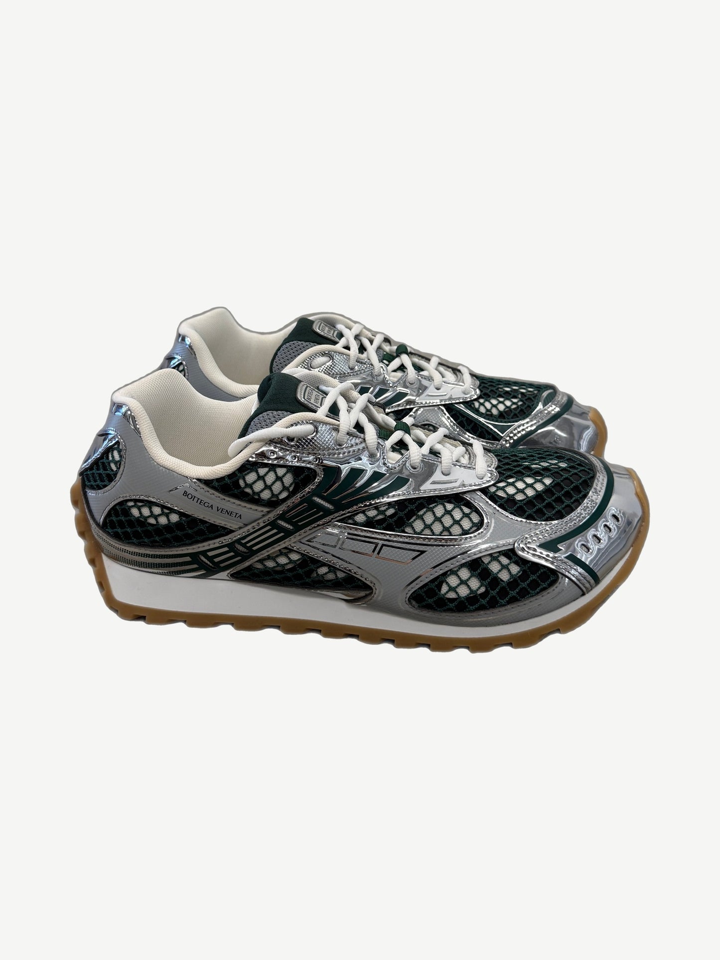 Bottega Veneta dark green Orbit sneaker side profile with chunky white sole and woven leather.