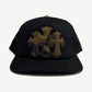 Chrome Hearts black trucker hat with triple leather cross patches in olive camo tones across the front panel