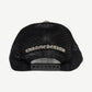 Chrome Hearts Cemetery trucker hat with multicolor cross patches scattered across black crown.
