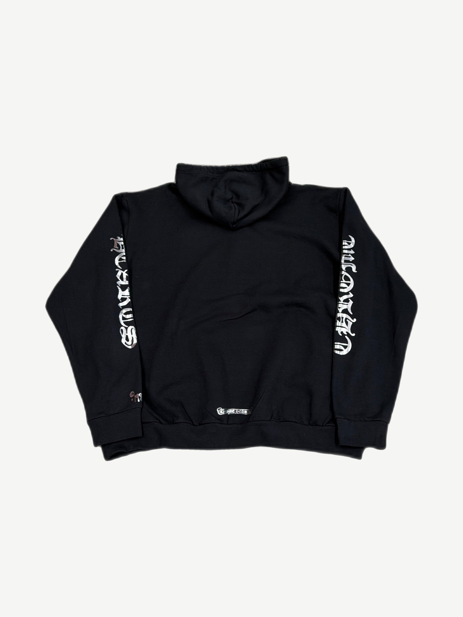 Back of Chrome Hearts 1988 black hoodie with silver metallic Chrome Hearts gothic script along sleeves