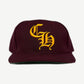 Chrome Hearts burgundy six panel baseball cap with yellow Old English CH embroidered logo.