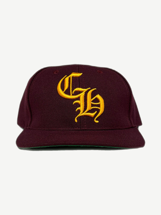 Chrome Hearts burgundy six panel baseball cap with yellow Old English CH embroidered logo.