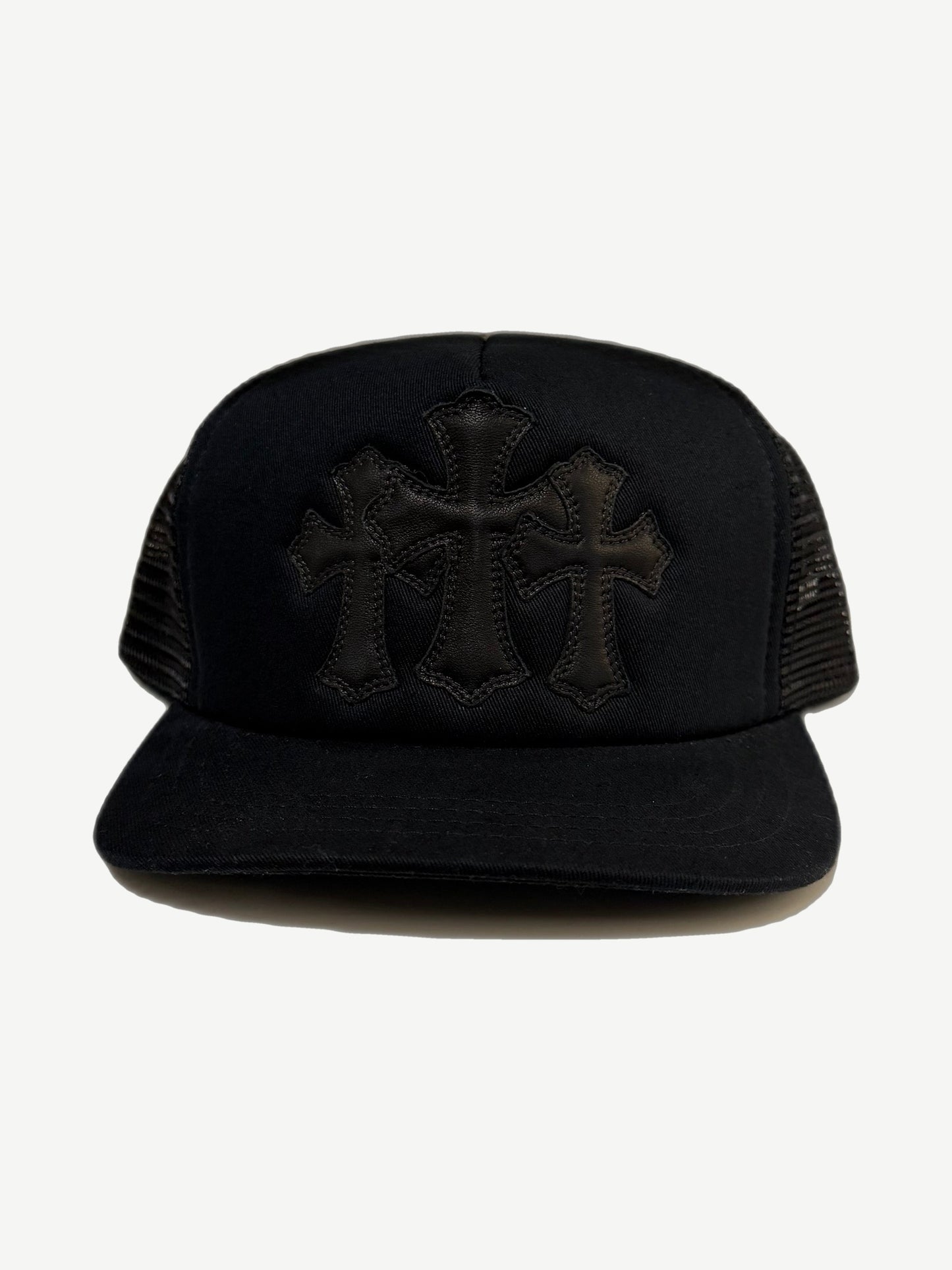 Chrome Hearts black trucker hat front with three stitched leather cross patches on twill crown and mesh sides