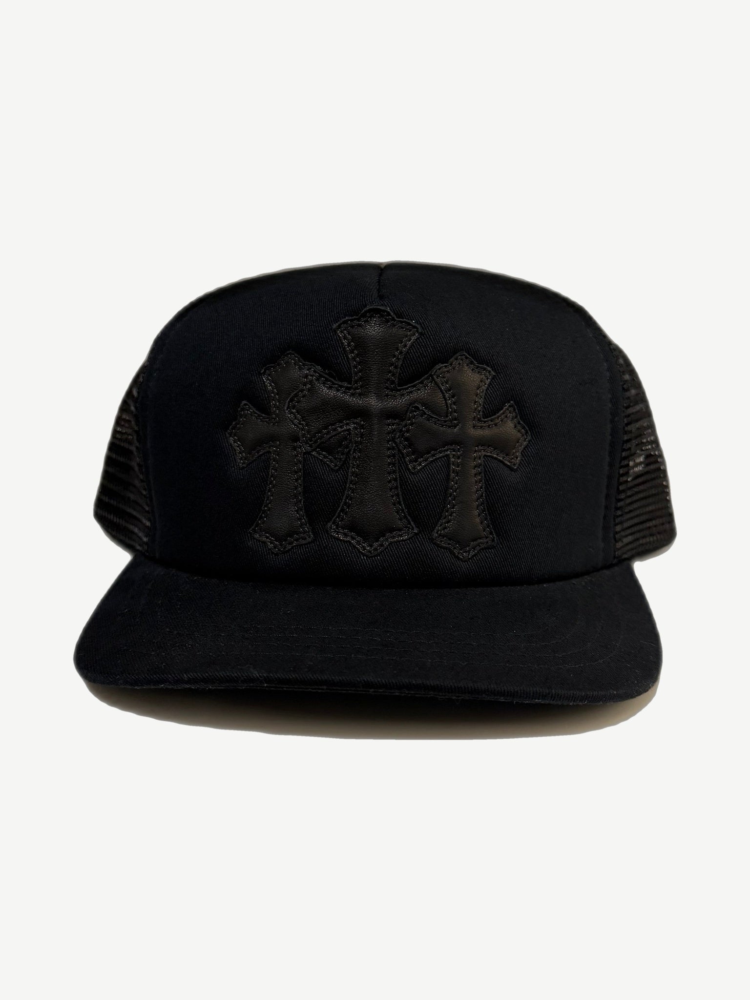 Chrome Hearts black trucker hat front with three stitched leather cross patches on twill crown and mesh sides