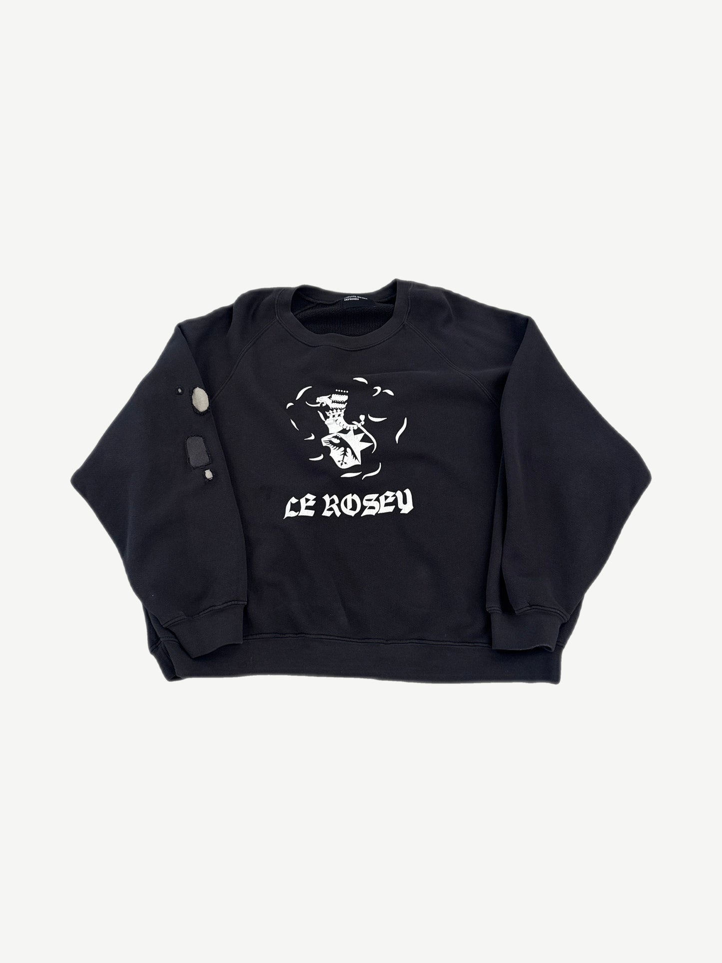 Enfants Riches Deprimes Le Rosey black raglan crewneck front with white gothic text and school crest graphic.