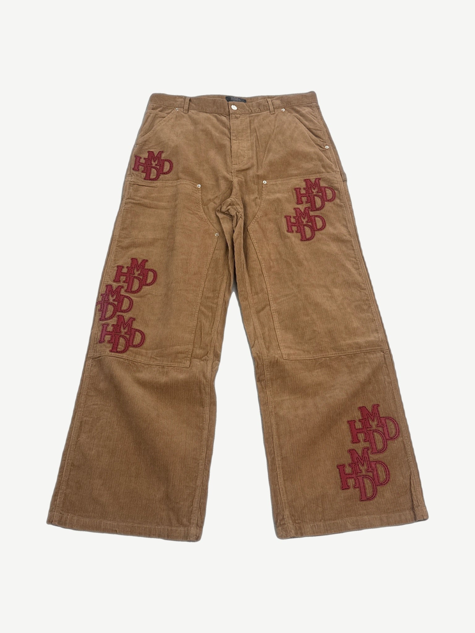 Happy Memories Don't Die HMDD tan corduroy pants front with stacked red HMDD monogram patches on legs