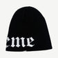 Supreme black beanie reverse side view showing tail of Old English Supreme script logo on the ribbed cuff