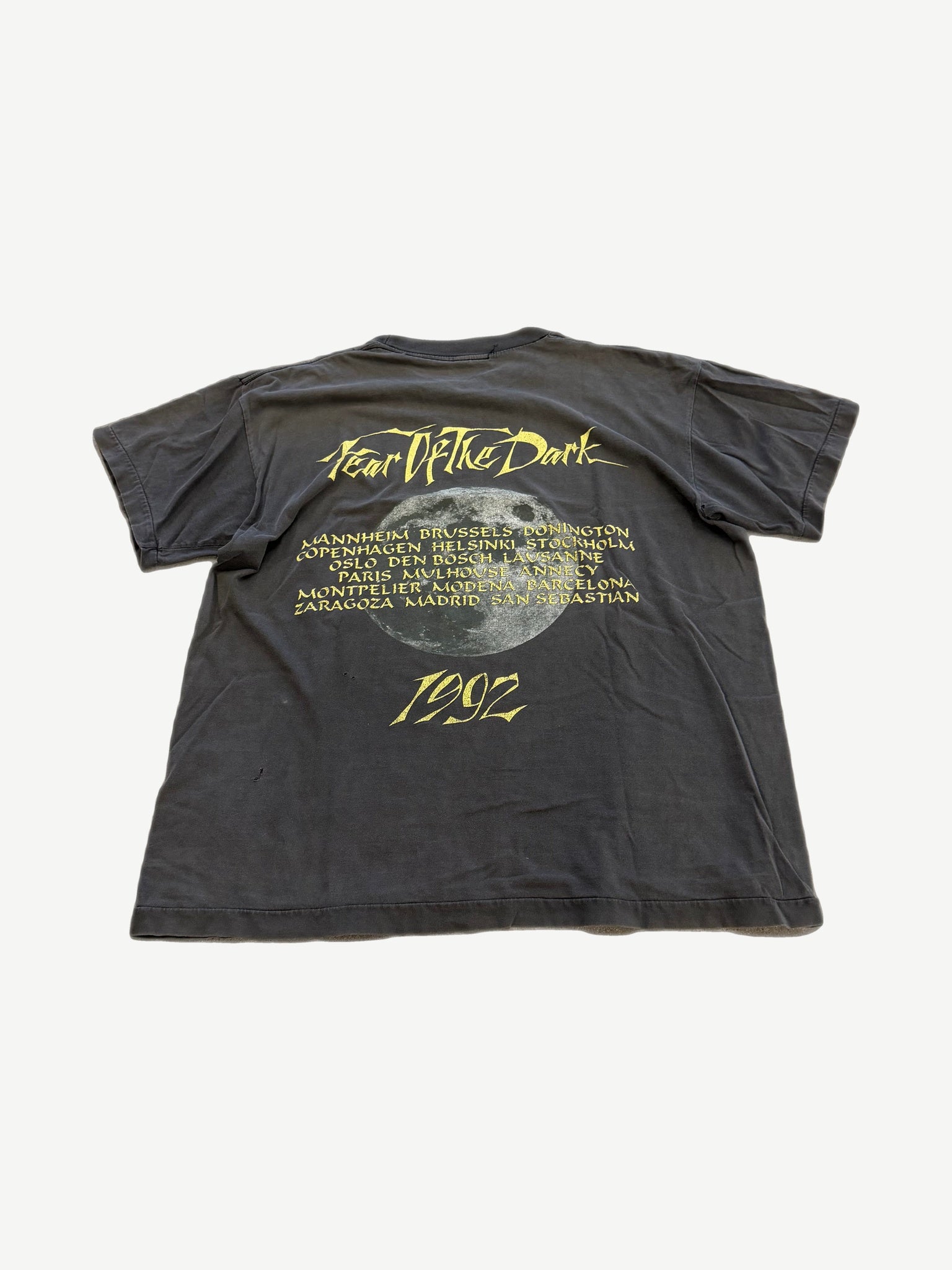 Back of vintage Iron Maiden Fear of the Dark tour tee with band logo and tour date list on faded black.