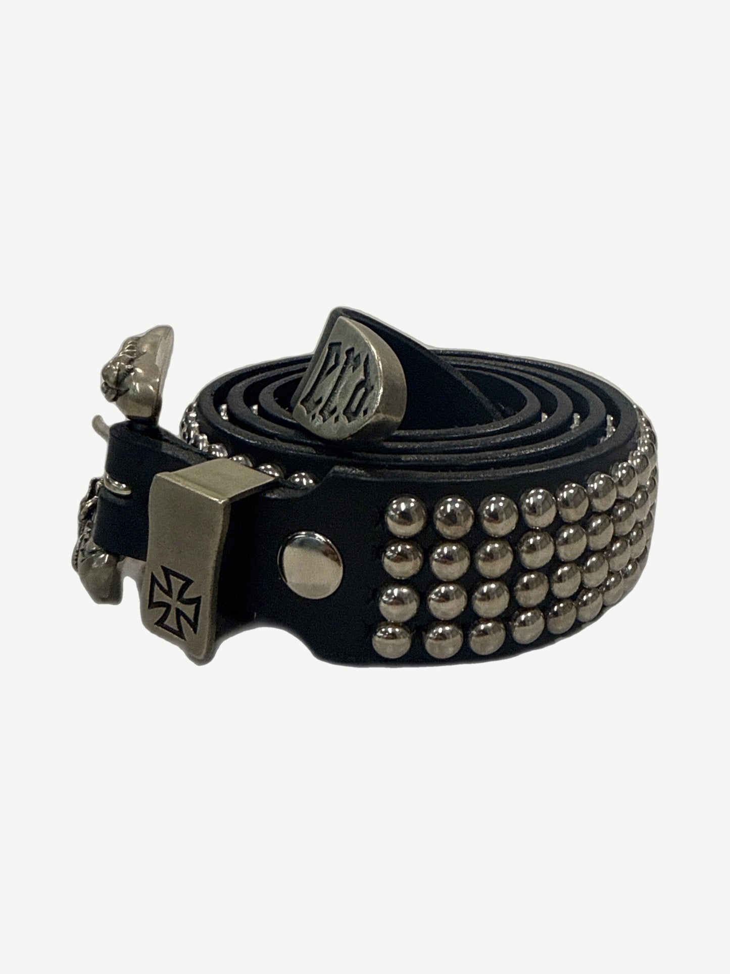 Enfants Riches Deprimes black leather coin belt coiled, showing skull and iron cross hardware with engraved tip