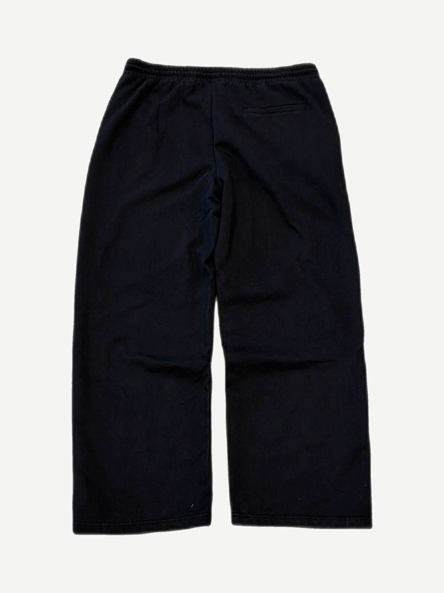 Bottega Desires black tech sweatpants back view, sleek nylon construction with rear welt pocket and tapered cuffs.