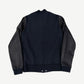 Back view of Chrome Hearts varsity jacket in navy wool with black leather raglan sleeves and ribbed cuffs