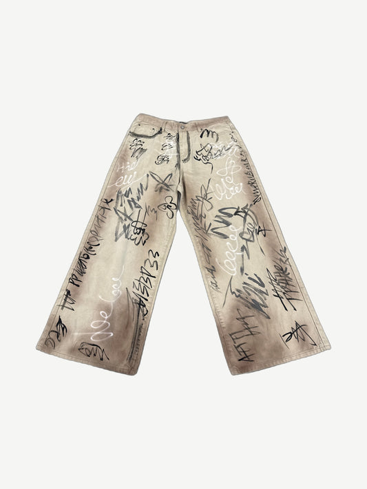 HMDD tan wide-leg chino pants with all-over black and white graffiti scribble print
