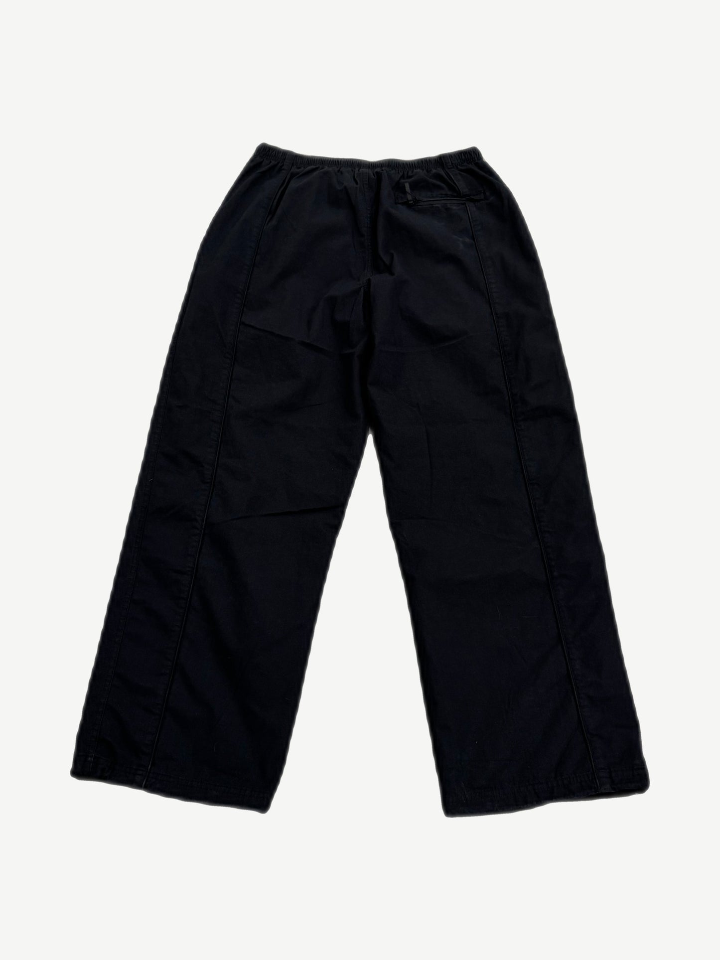 Supreme Umbro black ripstop track pants back view, clean black panels with right rear zip pocket detail.