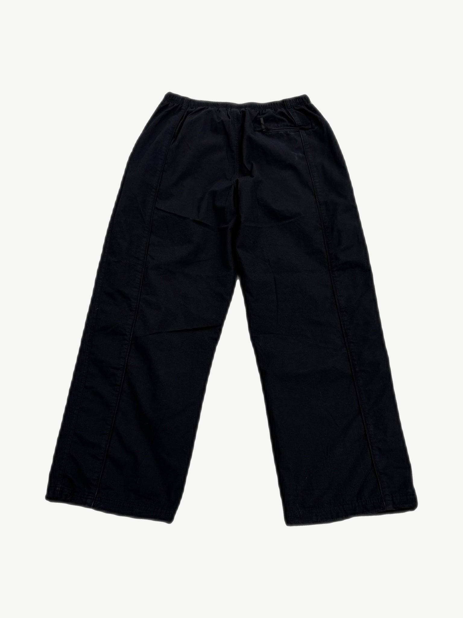 Supreme Umbro black ripstop track pants back view, clean black panels with right rear zip pocket detail.