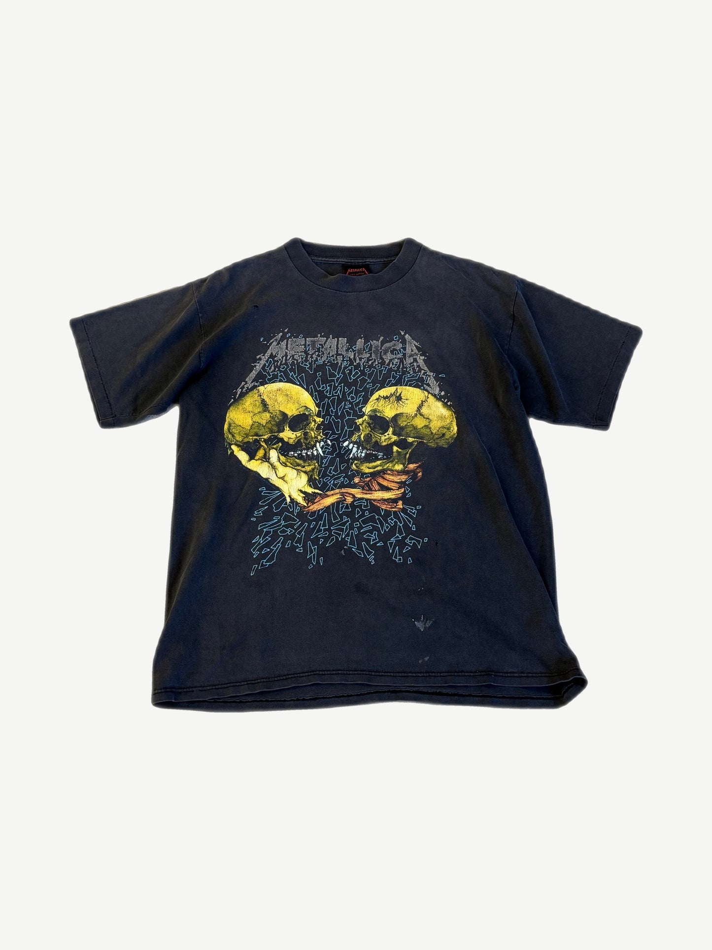 Vintage Metallica faded black tee front with Pushead twin yellow skulls fighting graphic and metallica logo print.