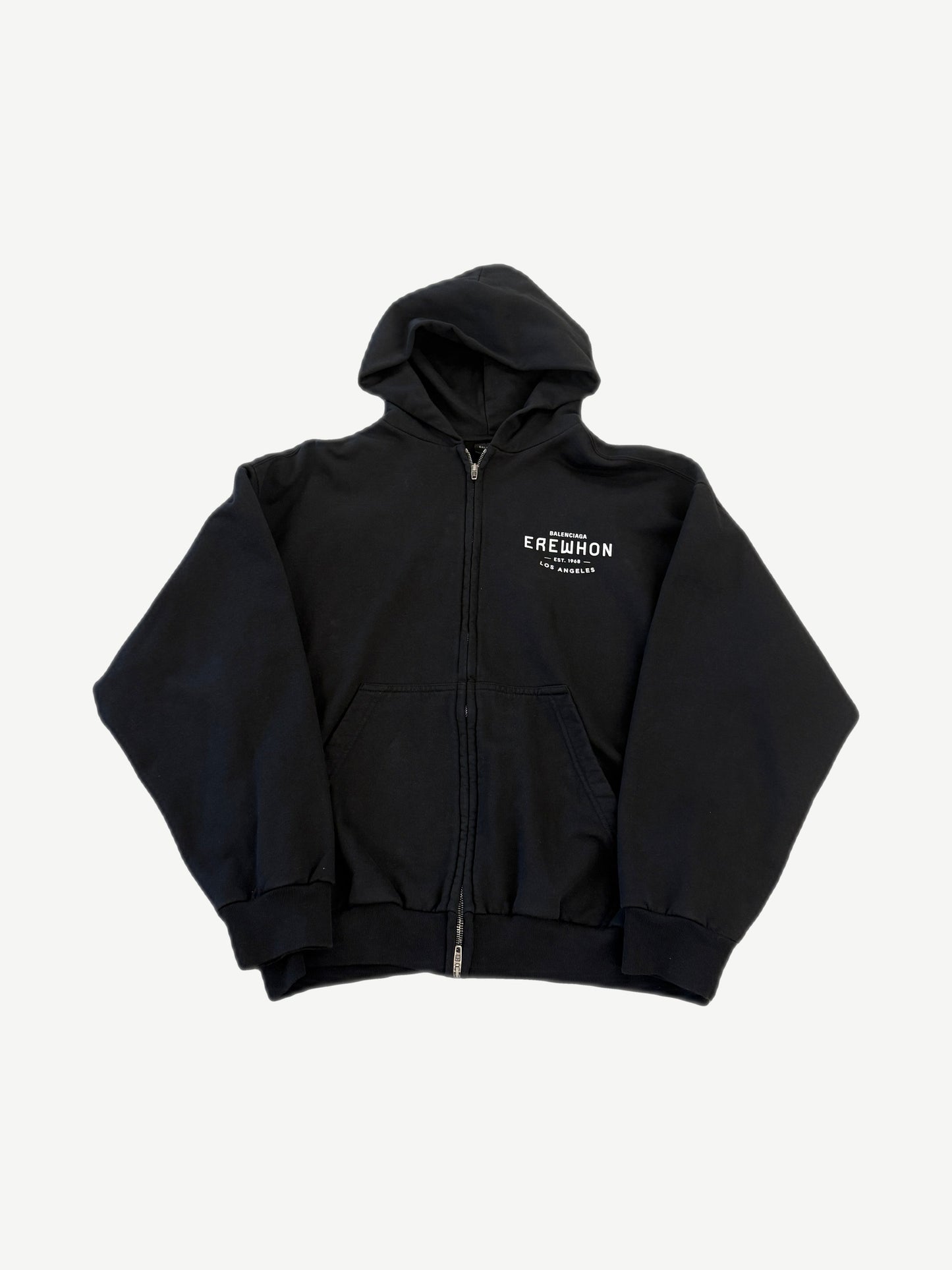Balenciaga black Erewhon zip-up hoodie with red and white Erewhon Market logo print on chest.