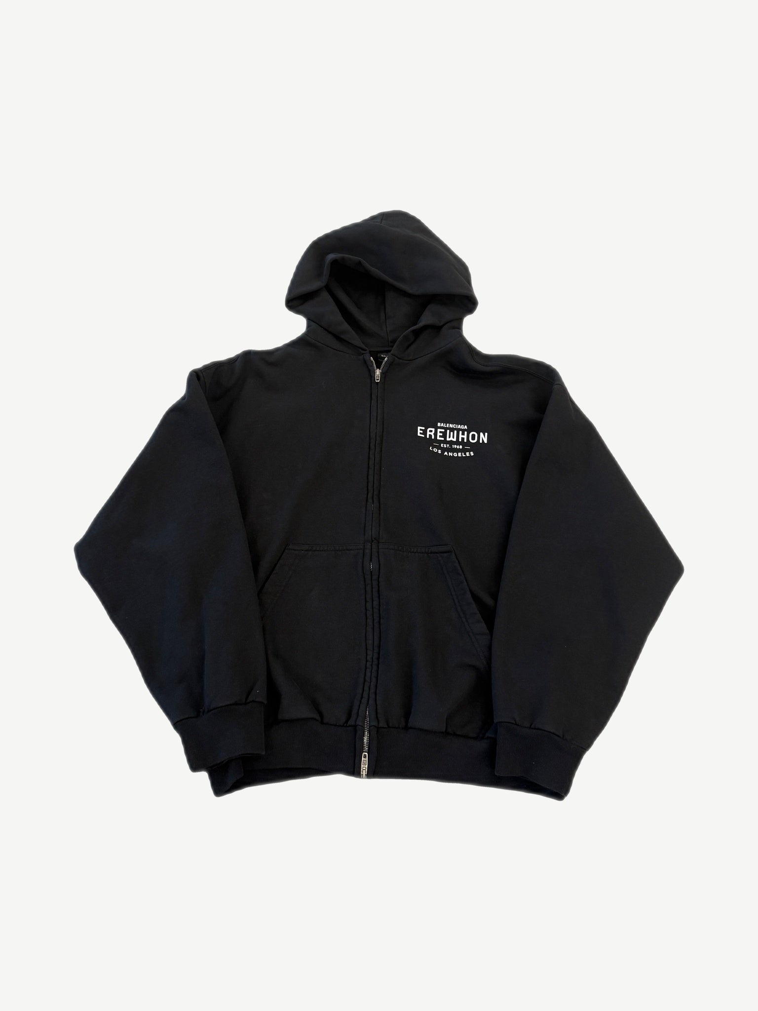 Balenciaga black Erewhon zip-up hoodie with red and white Erewhon Market logo print on chest.